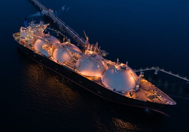 Nave gasiera illuminata di notte in mare aperto: articolo sulle aree di navigazione GMDSS